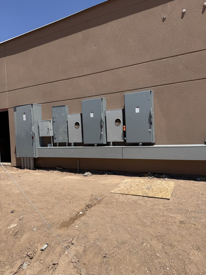 Row of completed electrical service disconnects mounted on a commercial building exterior