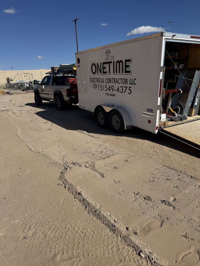 Onetime Electrical truck and branded work trailer parked on a job site