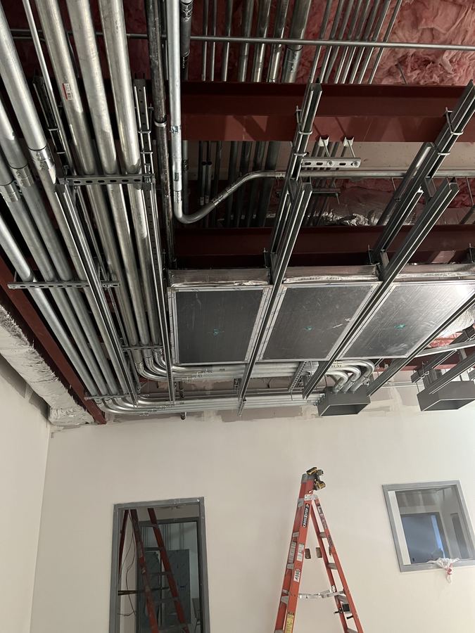 Parallel EMT conduit runs installed above a commercial ceiling