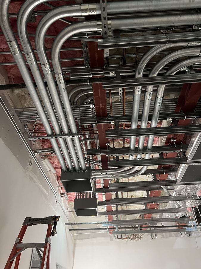 Bank of conduit sweeps bending into commercial electrical gear