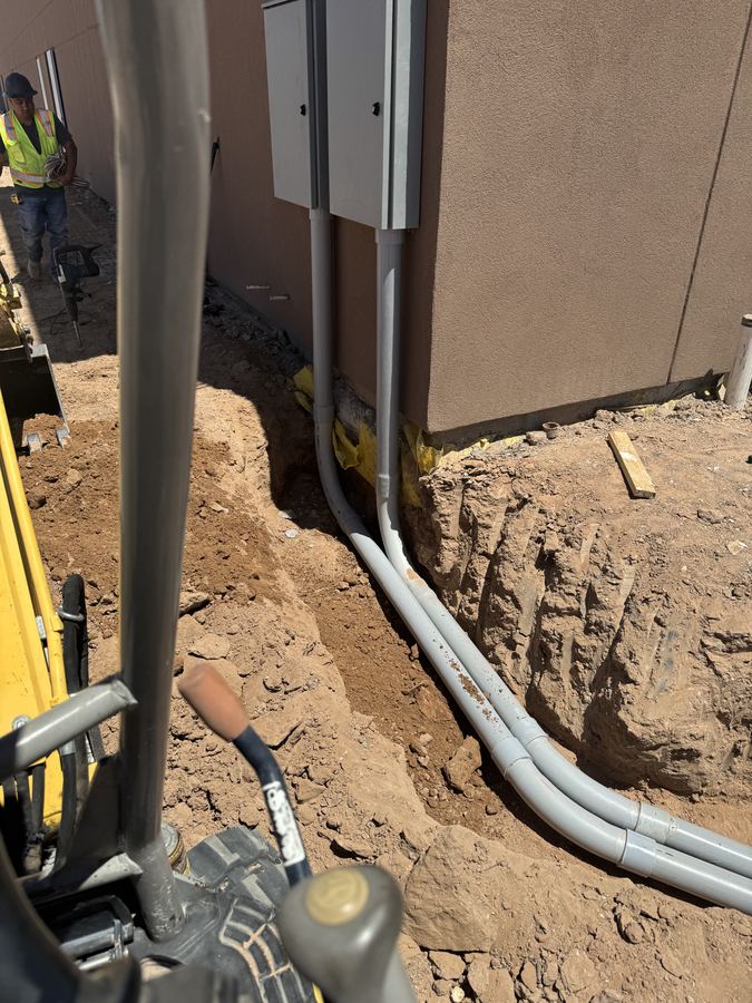 Underground electrical conduit installed in an open trench before backfill